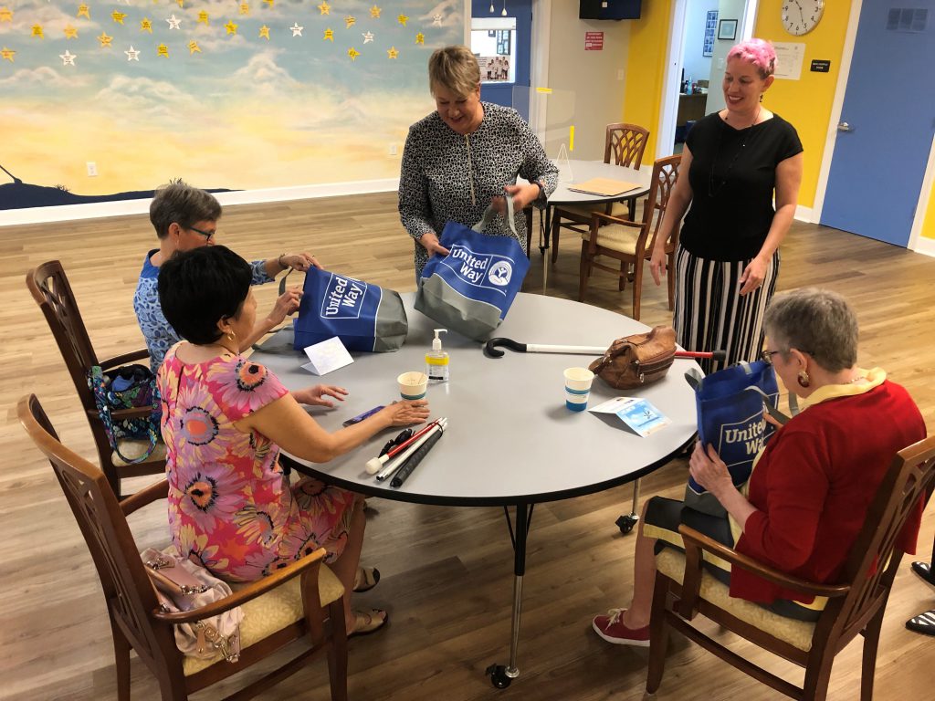 Women smiling with "United Way" bags